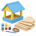 Natural pine bird feeder kit half-painted in sky blue and yellow beside panels, paint pots, brush and jute cord, on white